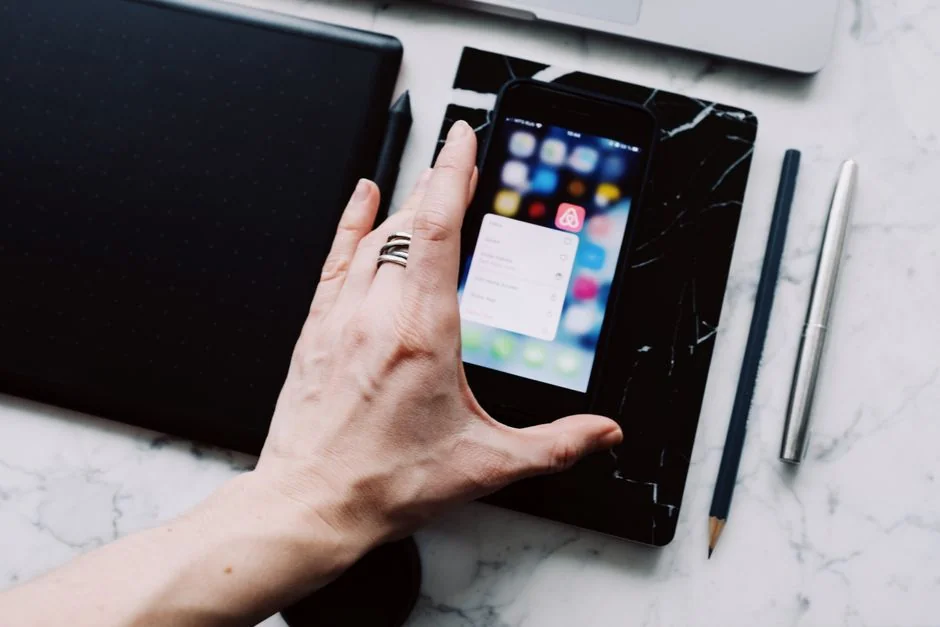 Un espace de travail lumineux avec un livre de design, un ordinateur portable et des outils créatifs, parfait pour trouver l’inspiration.